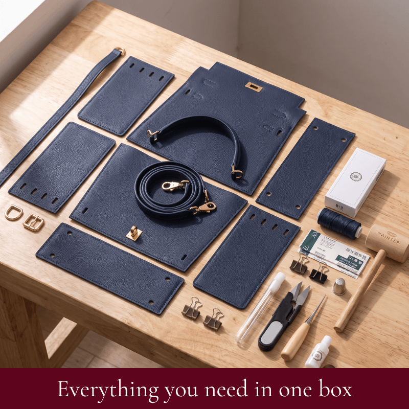 Grace DIY satchel kit contents in midnight blue: pre-cut leather pieces, hardware, strap and tools