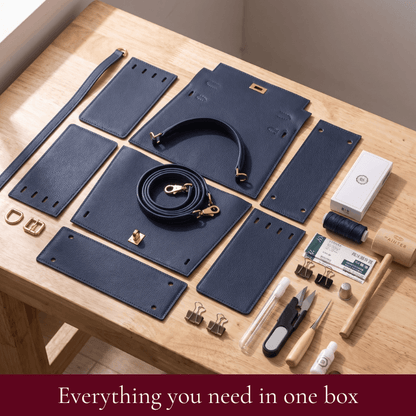 Grace DIY satchel kit contents in midnight blue: pre-cut leather pieces, hardware, strap and tools