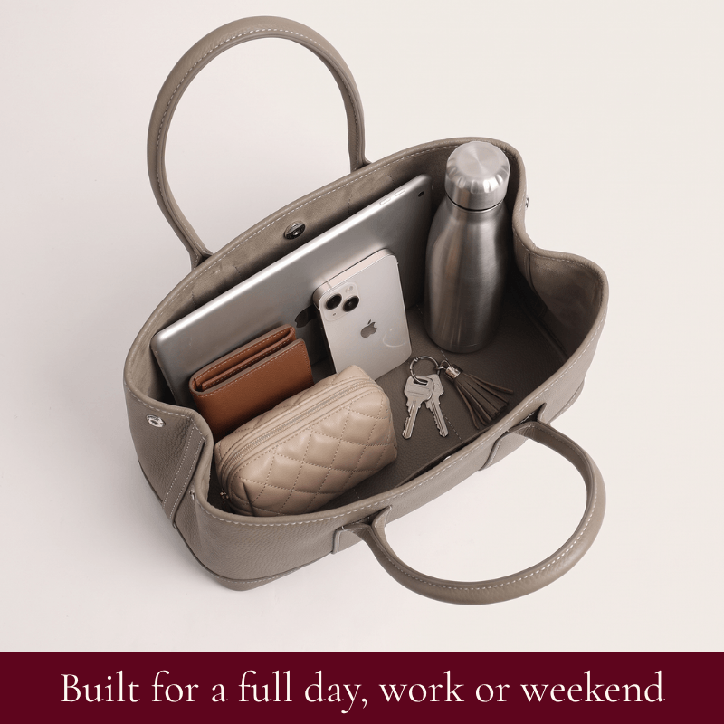 Interior of the Daphne leather tote in grey holding a tablet, water bottle and everyday essentials
